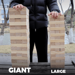Man standing behind two giant Jenga block towers demonstrating the enormous size.