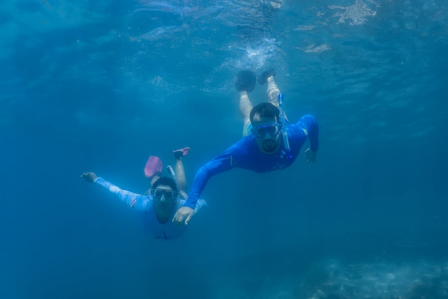 Casal vivendo uma experiência única de snorkel em Arraial do Cabo com a DiverTrip