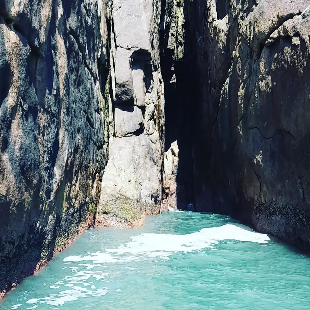 Passeio de barco na Ilha de Guarau: praias desertas e cachoeira