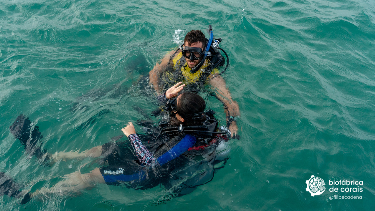 Bioturista acompanhado de instrutor de mergulho para fazer mergulho com cilindro nas piscinas naturais em Porto de Galinhas
