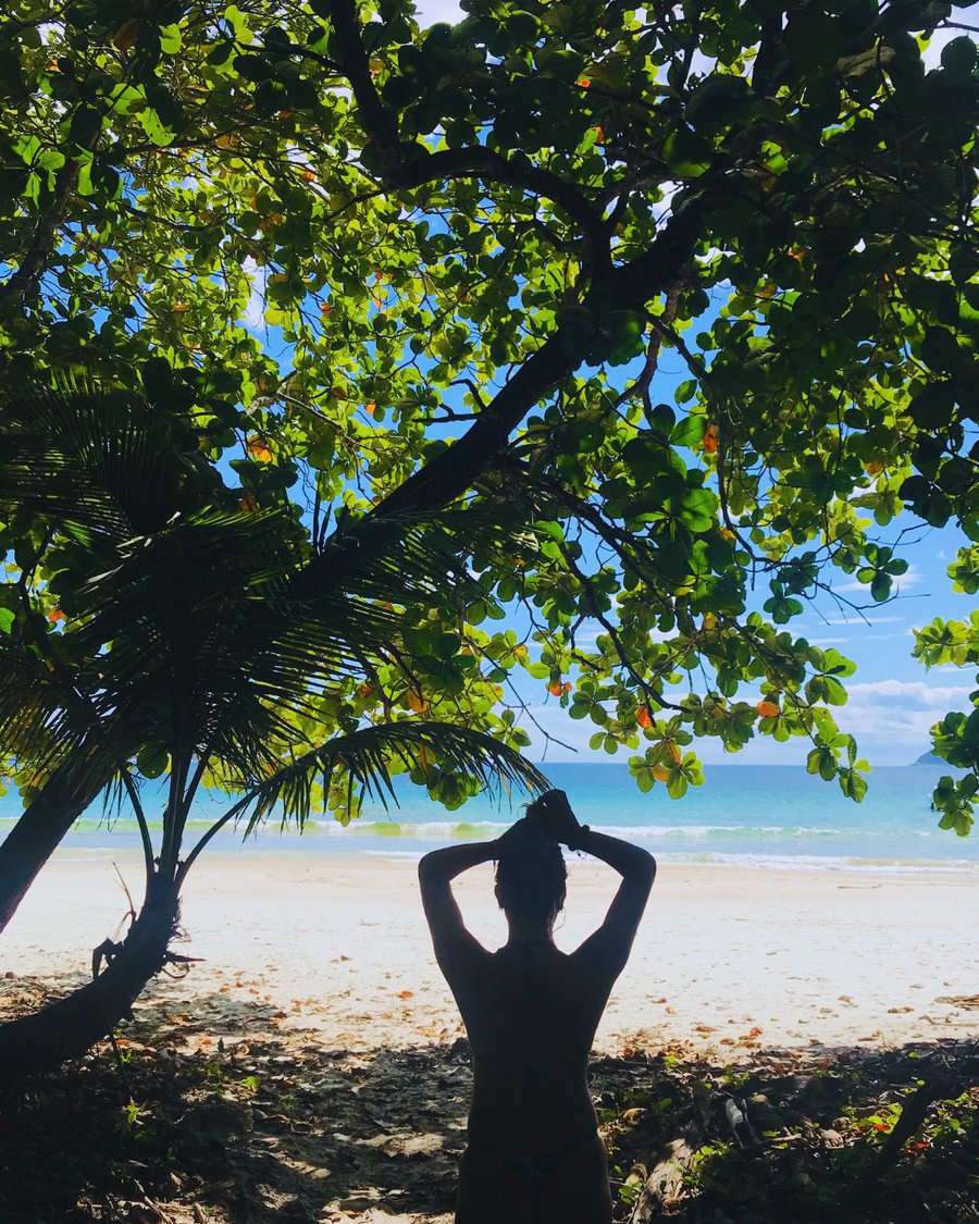 A trilha tem ao fundo um mar azul deslumbrante
