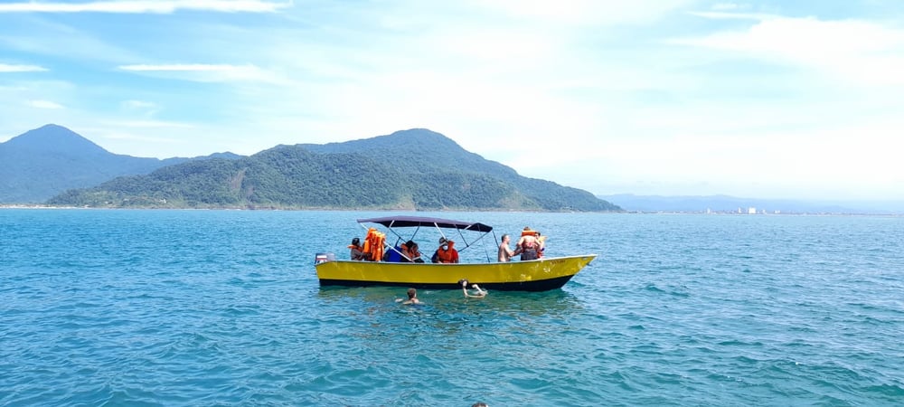 Passeio de barco na Ilha de Guarau: praias desertas e cachoeira