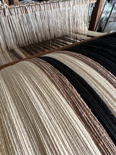 A artesã Emiliana expõe suas artes para o público, sendo uma das principais artesãs locais de Resende Costa.