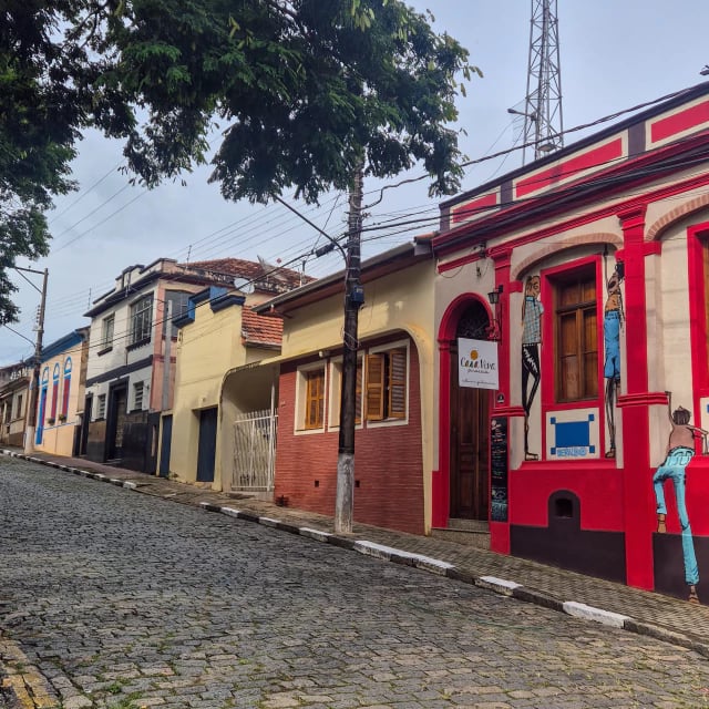 Rua de paralelepípedos do centro histórico de Piracaia com casarios coloridos