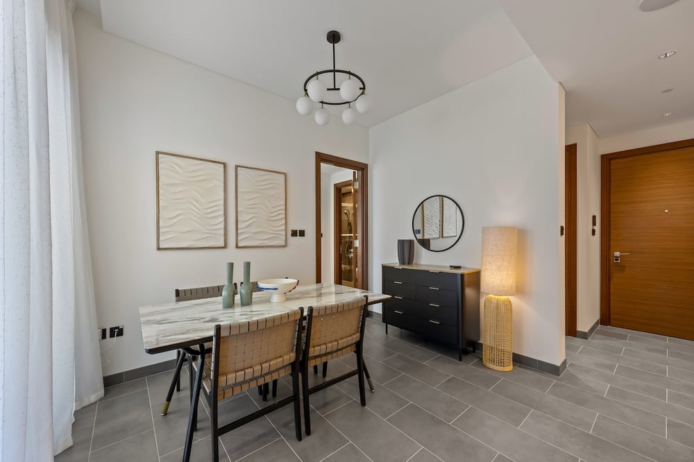 Dining area with table chairs pendant light and artwork