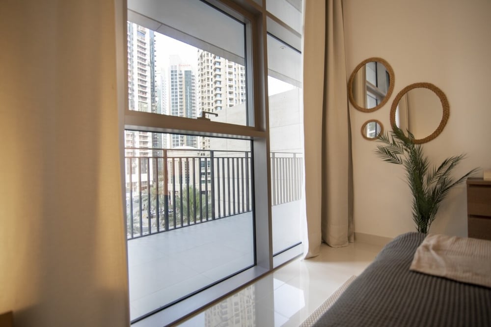 Bedroom balcony door with city skyline view and mirror decor