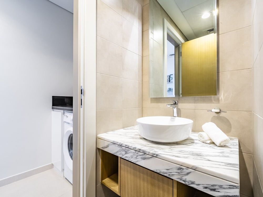 Bathroom with vessel sink, marble vanity and washing machine