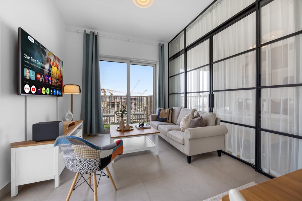Living area with sofa, TV, work desk, and city view
