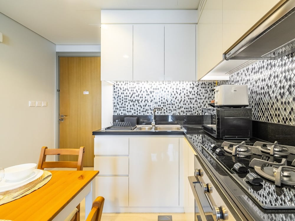 Kitchen with sink, gas hob, oven and dining table beside