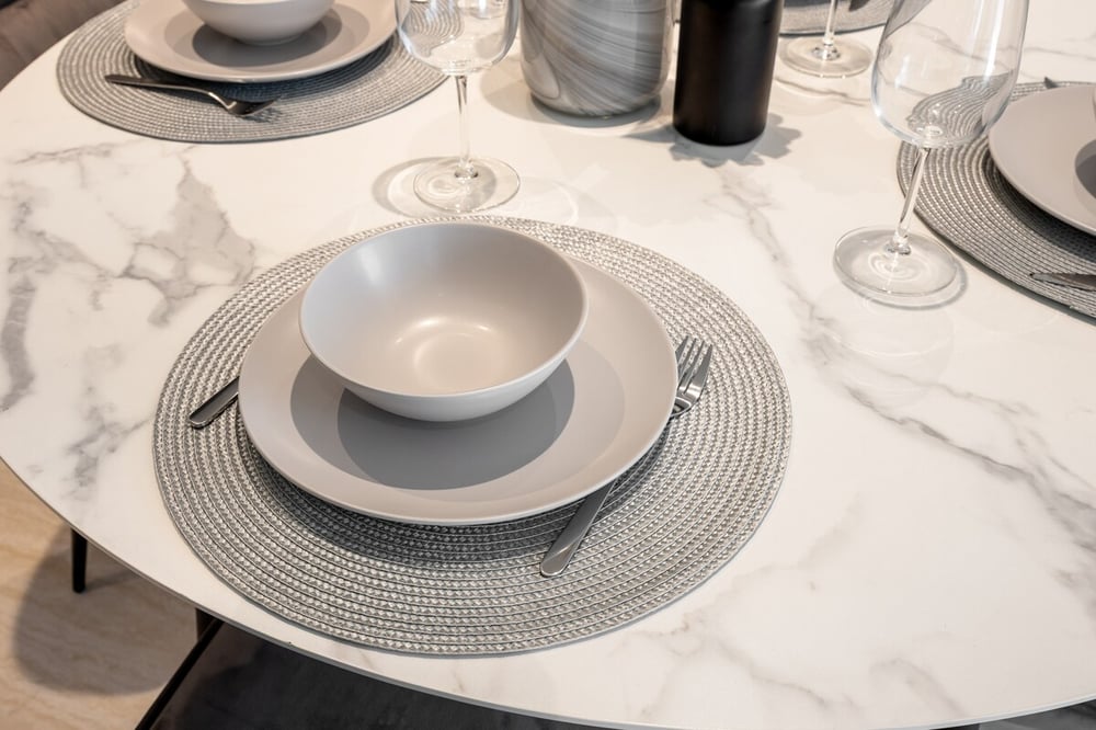 Close-up of marble dining table with place settings and wine glasses