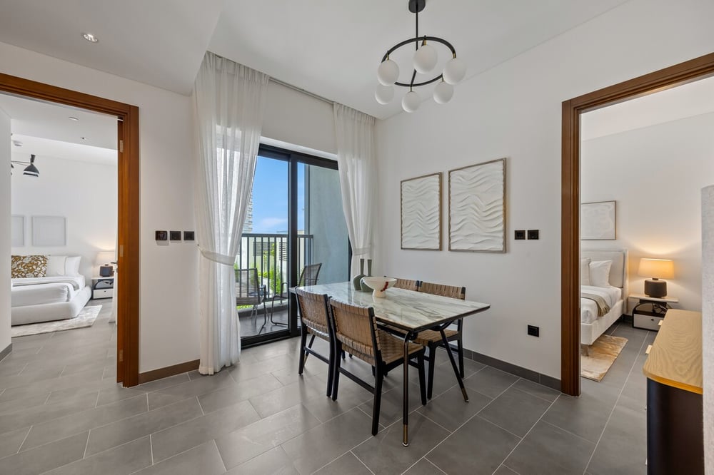 Dining area with balcony access and bedroom doorway visible