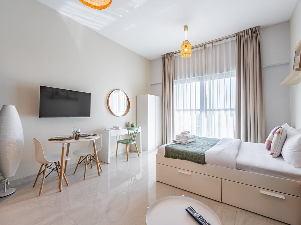 Studio with double bed TV dining table and kitchen