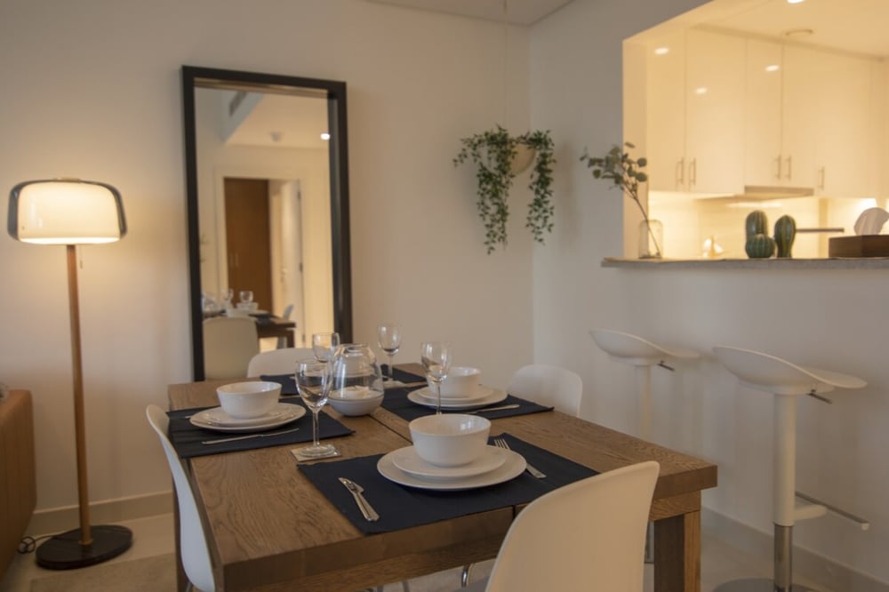 Dining area with table set for four and mirror on wall
