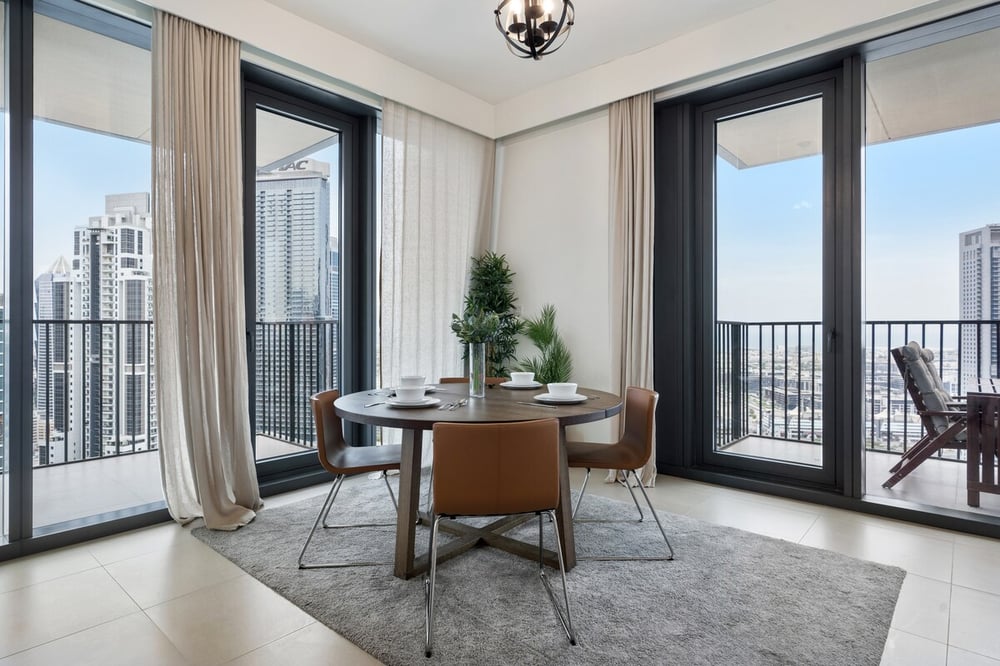 Dining area with round table and city view through large windows