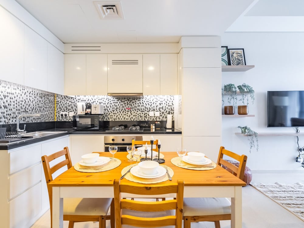 Dining area with yellow chairs and kitchen in open-plan layout