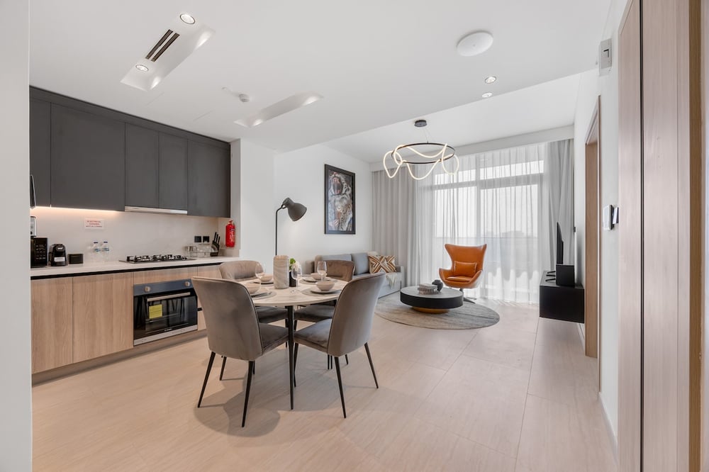 Open-plan kitchen and dining area with round table and living room beyond