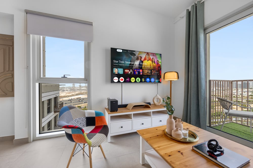 Living area with TV, work desk, sofa, and city view