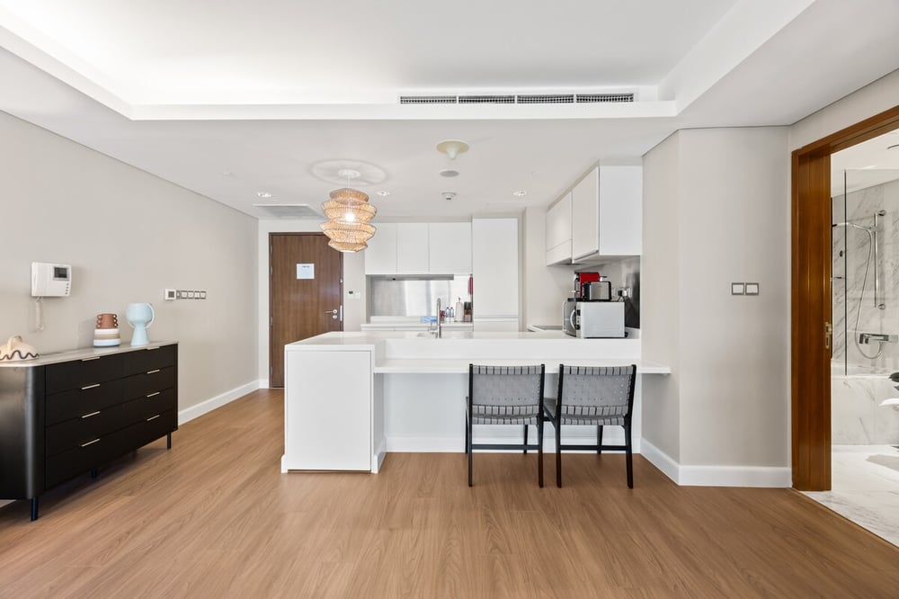 Open-plan studio living and kitchen area with hardwood floor