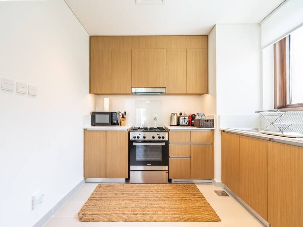 Kitchen with oven hob and overhead cabinetry
