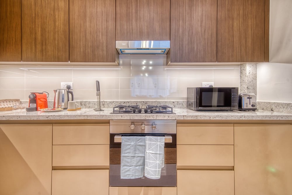 Kitchen counter with hob, kitchen hood and microwave