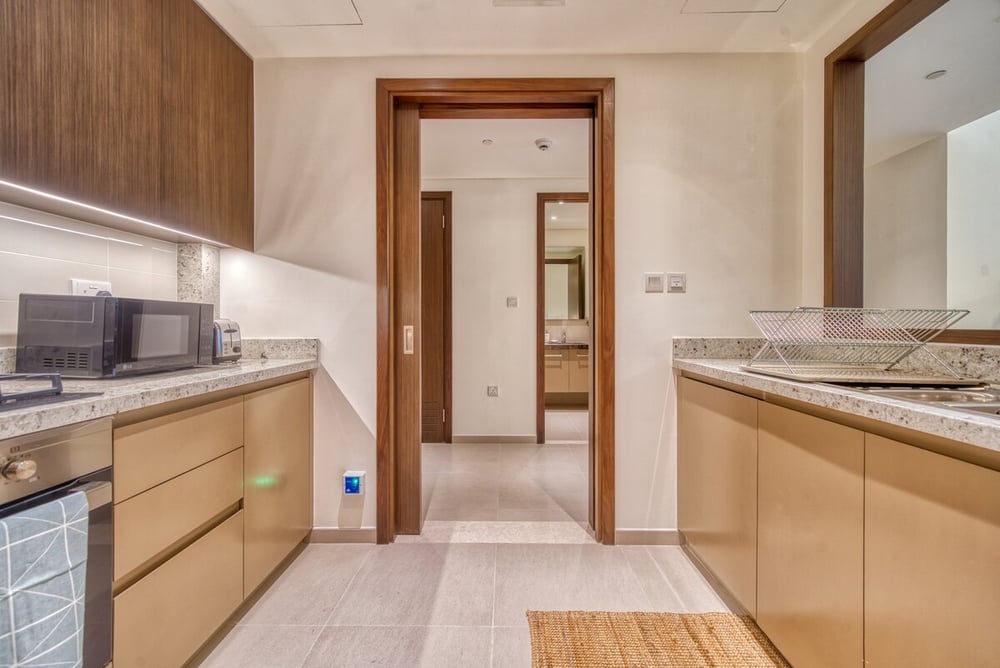 Kitchen corridor view with cabinets and doorway