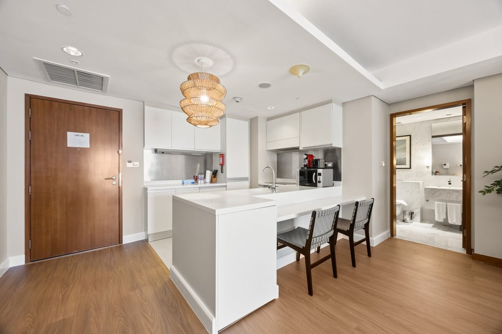 Kitchen island with bar stools and view toward bathroom
