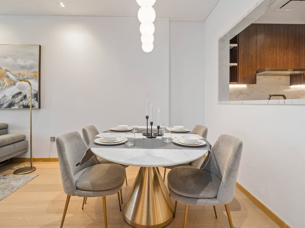 Round dining table with grey chairs and pendant light