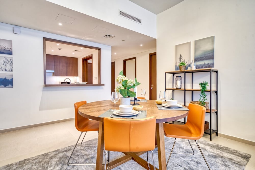 Dining area with round table and orange leather chairs
