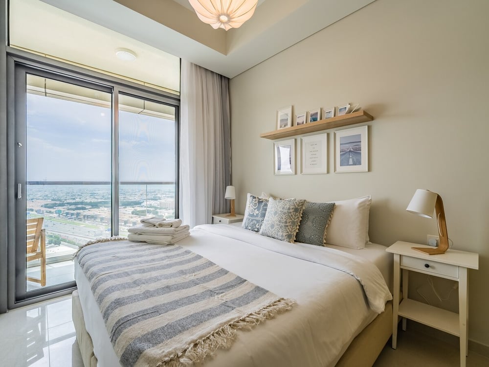 Bedroom with double bed, nightstand and city view window
