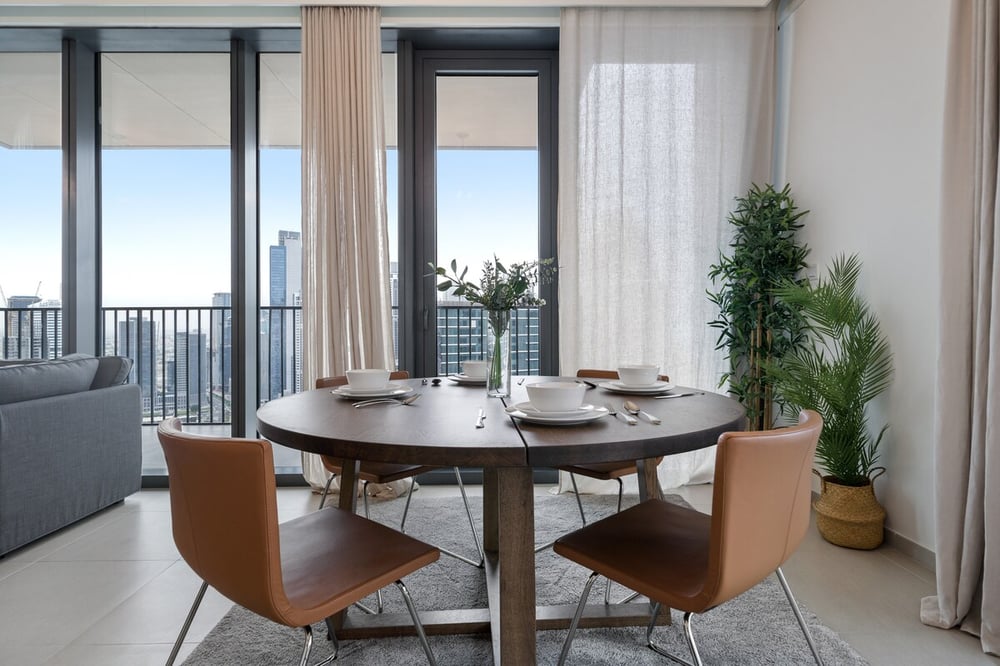 Dining area with round table and four chairs near balcony