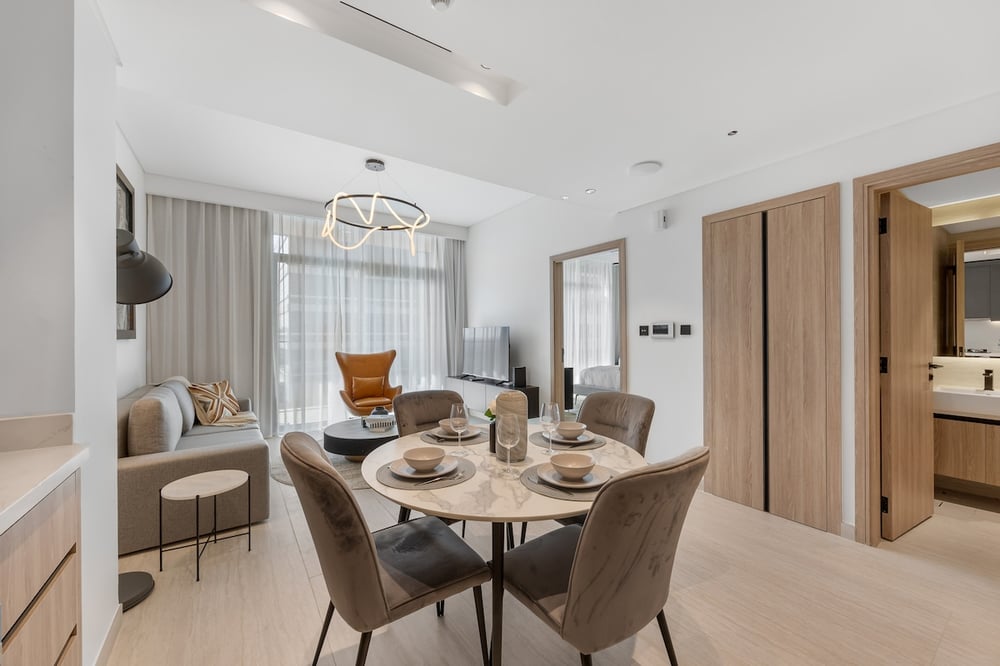 Dining area with round marble table and upholstered chairs