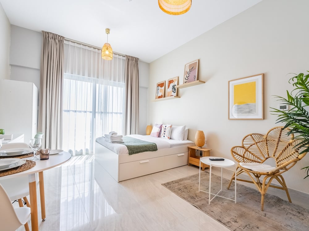 Studio living area with sofa bed dining table and TV