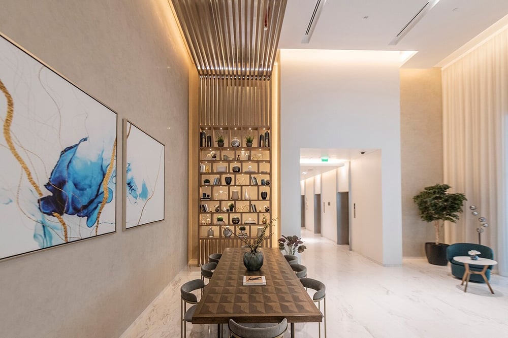 Building common area with long dining table and bookshelf wall