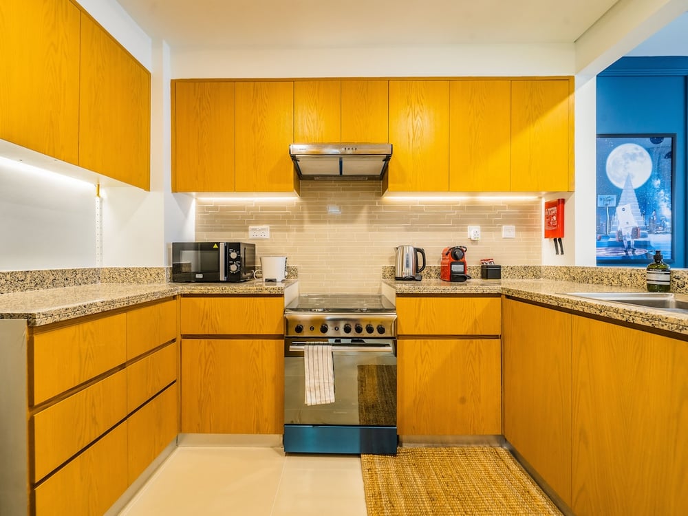 Kitchen yellow cabinets gas stove and microwave