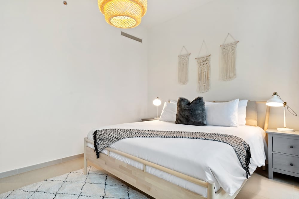 Bedroom with king bed and macrame wall art