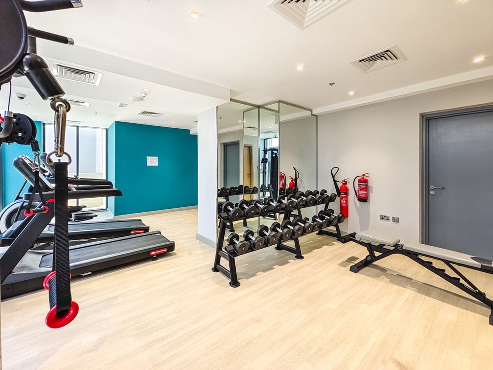 Gym with weights treadmill and mirrored wall