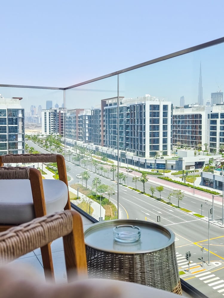 Balcony with rattan chairs and city street view