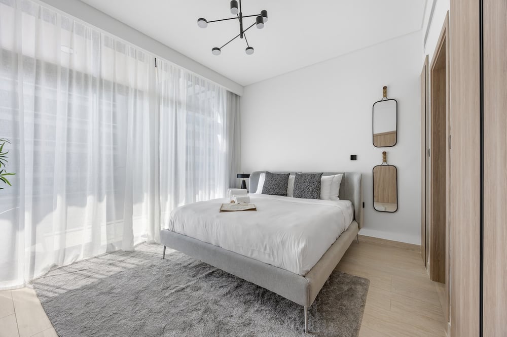 Bright bedroom with double bed and floor-to-ceiling windows