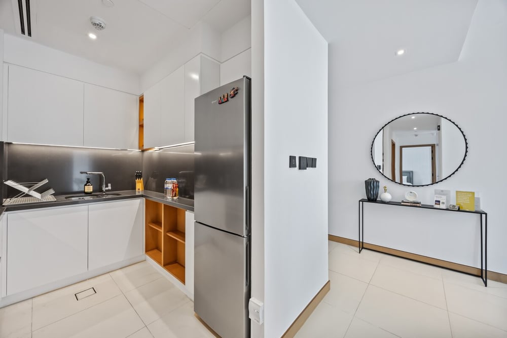 Kitchen with fridge and round mirror in hallway