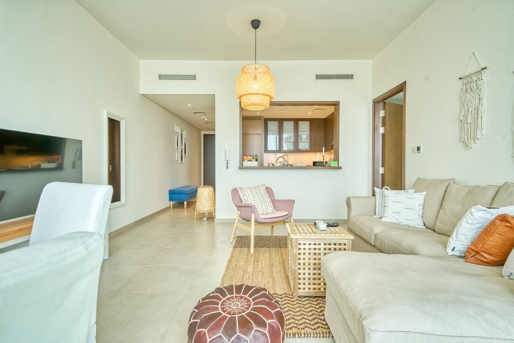 Living room showing open kitchen bar and TV area