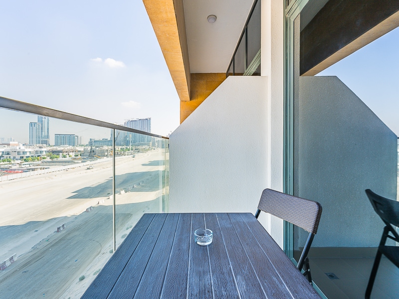 Balcony with table and chairs city view