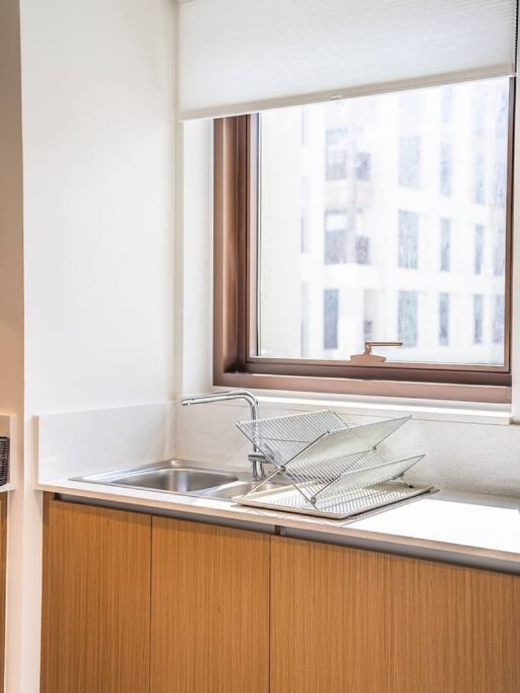 Kitchen sink area with window and wooden cabinets