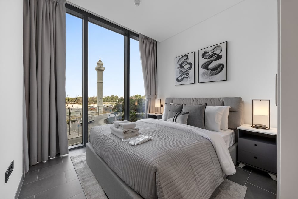Bedroom with double bed, nightstands and floor-to-ceiling windows