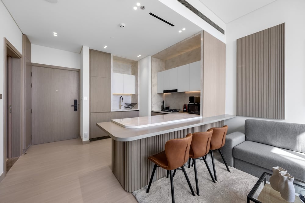 Open-plan kitchen island with bar stools and sofa beyond