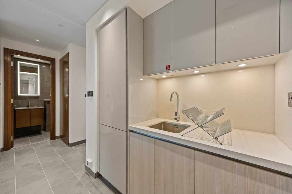 Kitchen sink area with cabinets and view to bathroom