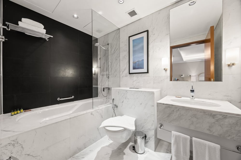 Marble bathroom with bathtub, shower, toilet and vanity