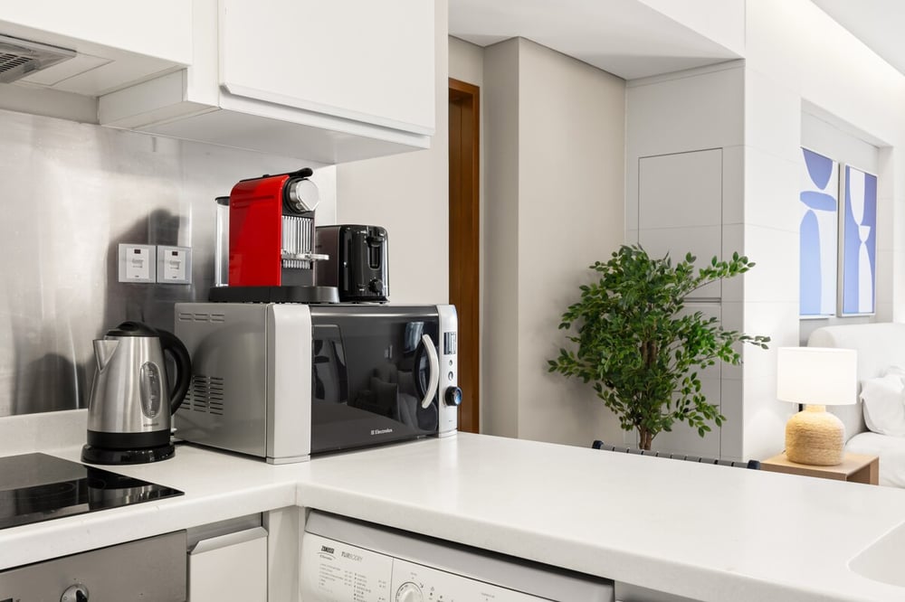 Kitchen with coffee maker, kettle, microwave and induction hob
