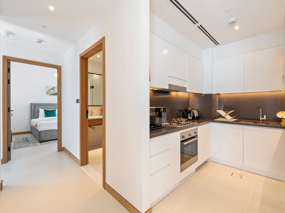 White kitchen with appliances and view into bedroom