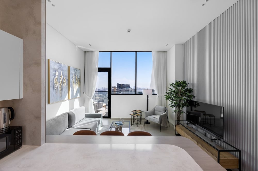 Open-plan living area with TV, sofa and floor-to-ceiling window
