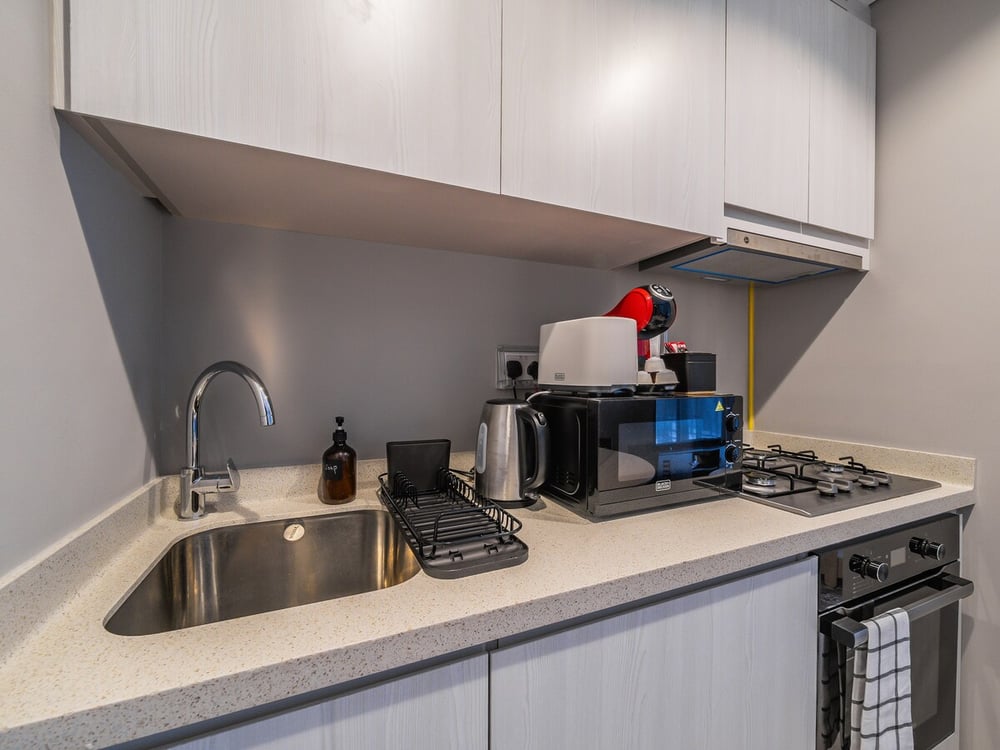Kitchen counter with sink toaster microwave and gas hob
